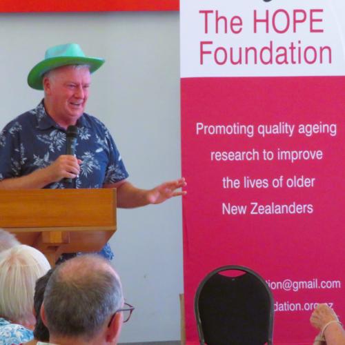 Man with green hat at lectern